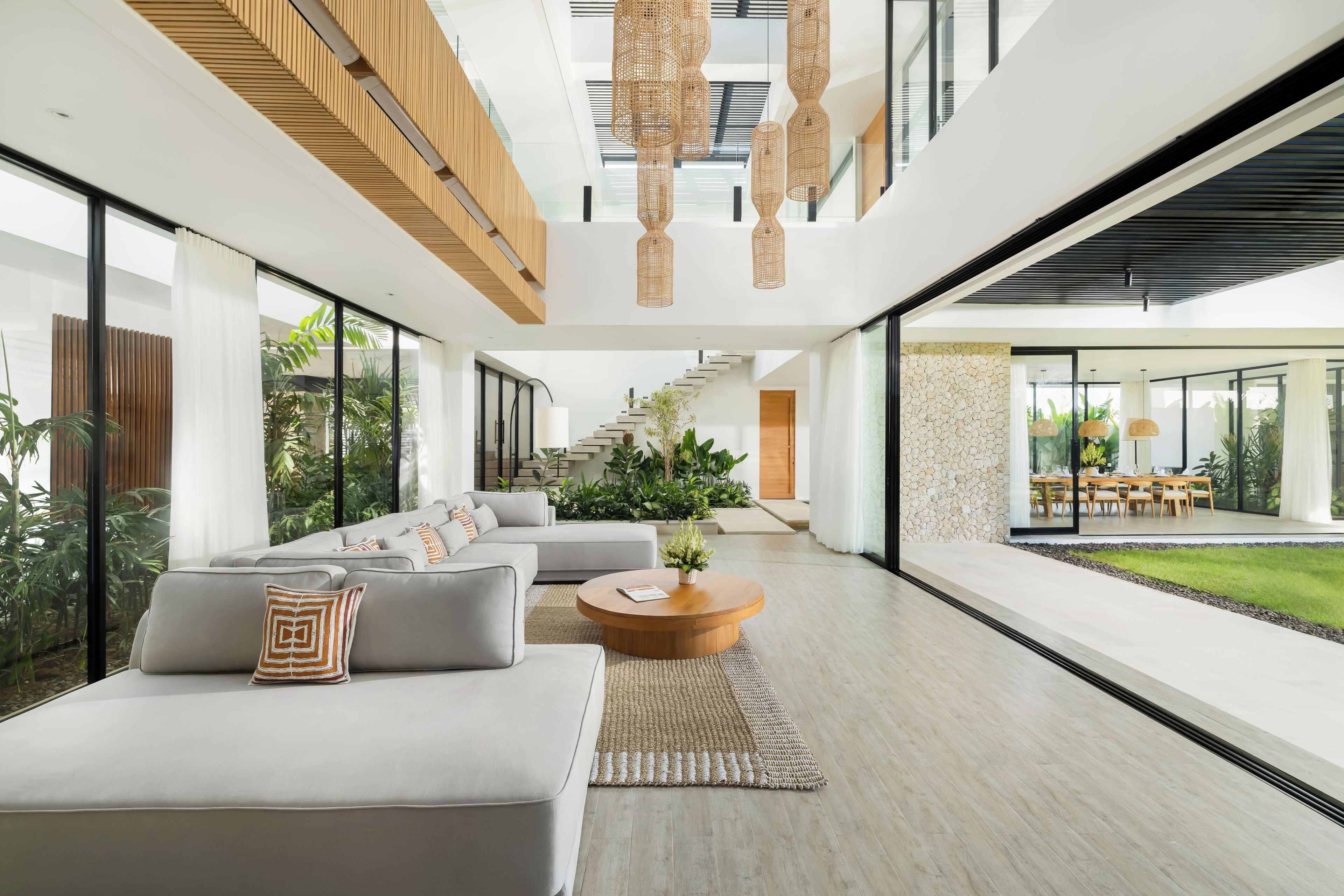 A modern interior with a sofa, coffee table, and staircase leading to an outdoor area.
