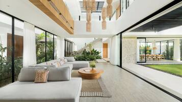A modern interior with a sofa, coffee table, and staircase leading to an outdoor area.