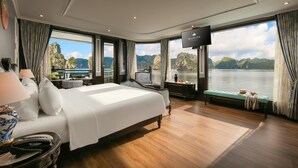Ein geräumiges Schlafzimmer mit einem großen Bett, einem Fernseher und Blick auf das Wasser.
