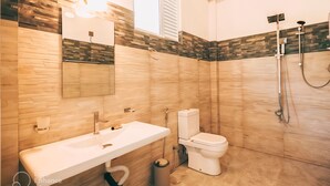 Et moderne badeværelse med en trækommode, toilet og bruseområde.