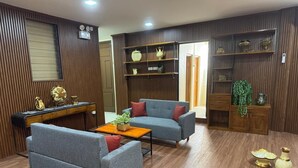 A modern living room with a sofa, coffee table, and decorative items. - Kostkan House (Jakarta)