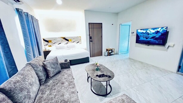 Una sala de estar moderna con un sofá, una mesa de centro y un televisor montado en la pared.