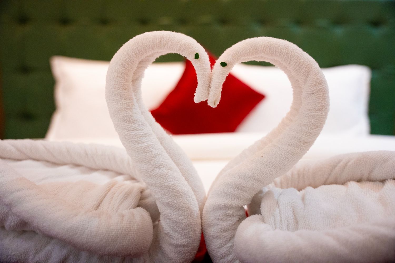 Un letto con asciugamani bianchi disposti a forma di cigno.
