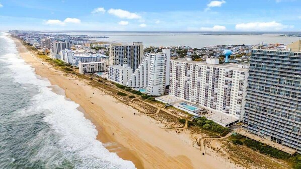 Een kusthotel met meerdere hoge gebouwen, een strand en uitzicht op de oceaan.