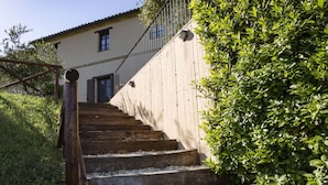 A set of outdoor stone steps leading up to a building with a metal railing. - Farmhouse in Marche With Pool & Wine Tours (Montecarotto)