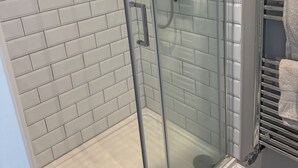 A glass-enclosed shower with a white-tiled wall. - Tranquil Loft Apartment Overlooking Countryside (Hailsham)