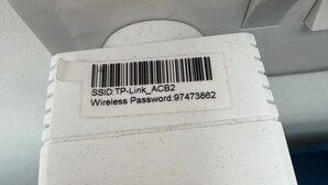 A white device with a barcode and text indicating a wireless password. - Tranquil Loft Apartment Overlooking Countryside (Hailsham)