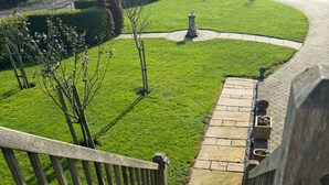 A staircase leading to a garden area with a paved path, wooden railing, and stone steps. - Tranquil Loft Apartment Overlooking Countryside (Hailsham)