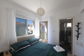 A bedroom with a bed, curtains, a hanging light fixture, and a view of the outside. - Protaras Blue River Villa Br26 (Paralimni)