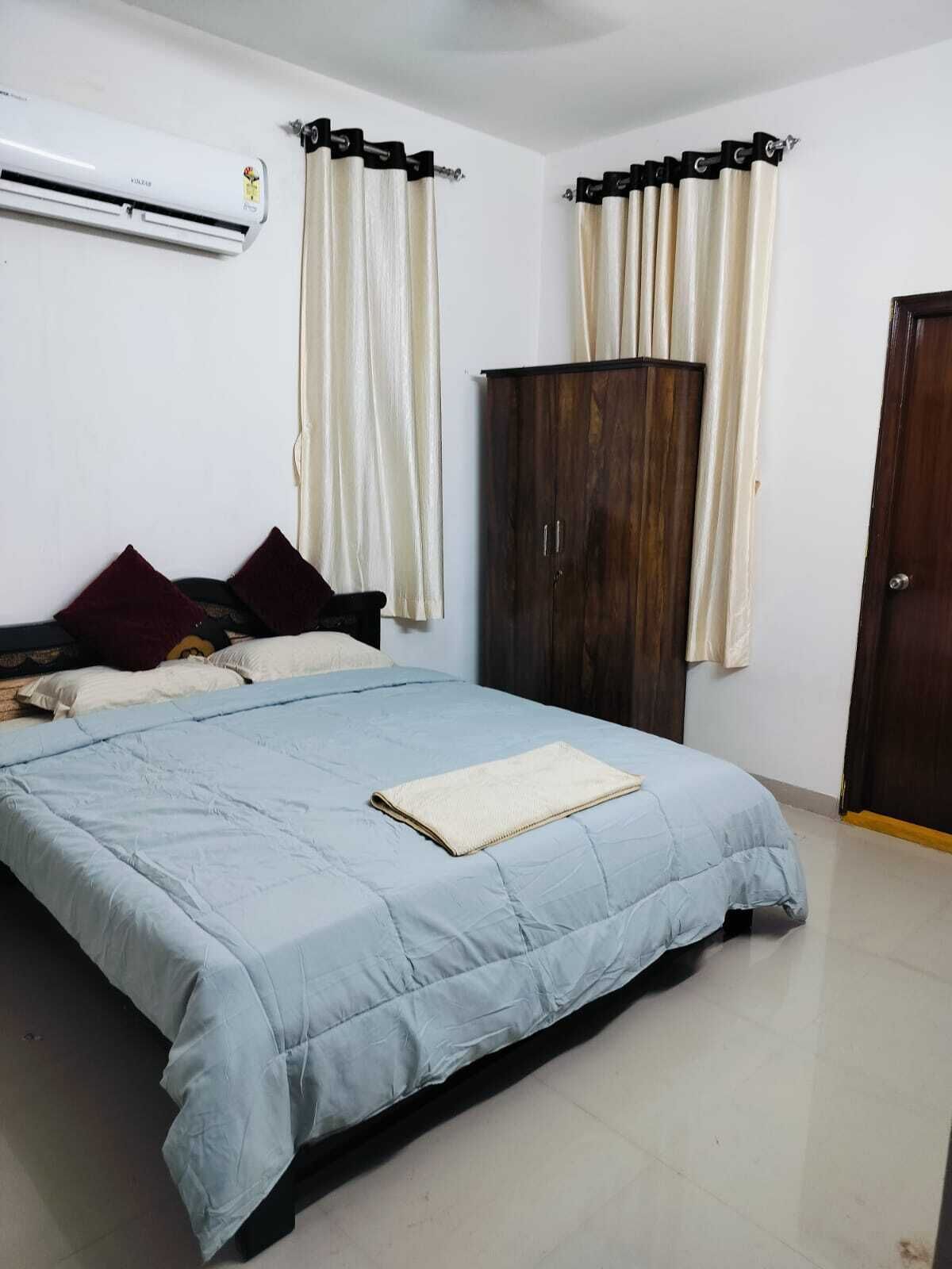 Una camera da letto con un letto, un armadio e un condizionatore d'aria.