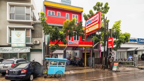 Une scène de rue avec un bâtiment aux couleurs vives abritant une pharmacie et un salon de manucure.