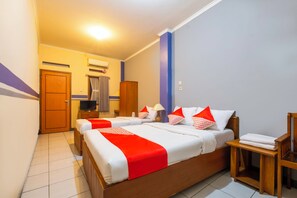 A hotel room with a large bed, a wooden wardrobe, a television, and a bathroom with a shower and toilet. - Hotel O Riau Near Gedung Sate Formerly Patradisa (Bandung)