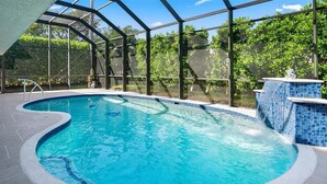 An indoor swimming pool with a clear view of the surrounding greenery and a tiled floor. - 3BR Marco Island home with heated pool, WiFi and full kitchen. (Marco Island)
