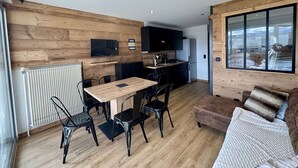 Un espacio habitable compacto con cocina, comedor y zona de estar.
