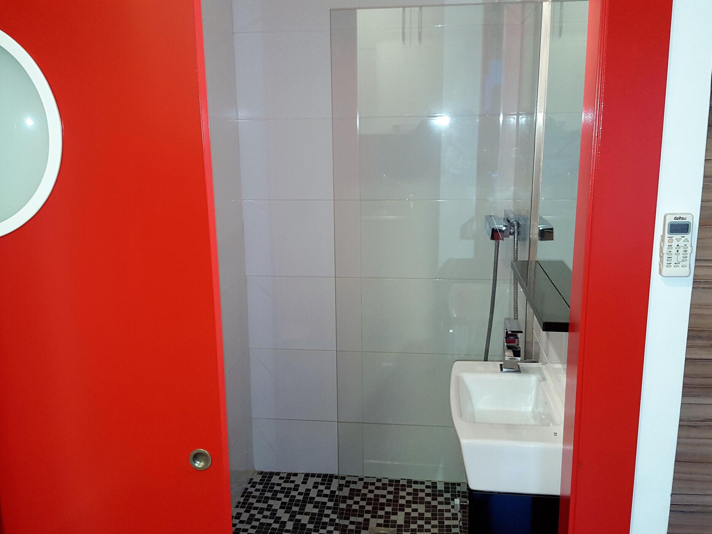 A bathroom with a shower, a toilet, and a sink.