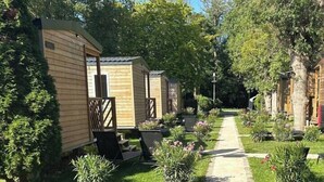 Una fila de casas móviles con un sendero pavimentado entre ellas, rodeado de vegetación y árboles.
