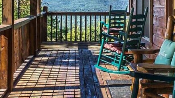A wooden deck with a view of a mountain, wooden chairs, and a table. - Escape to Serenity: Cozy Mountain Cabin with Mountain View/Pet Friendly (Sevierville)