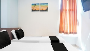 A hotel room with two beds, a TV on the wall, and a painting of a sunset. - Collection O Bukit Kecil Near Palembang Indah Mall  Formerly Hostel 77 (Palembang)