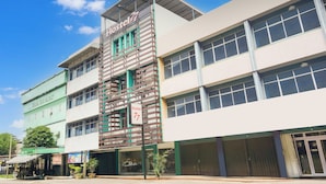 A hostel with a sign indicating room number 77, featuring a modern design with a mix of brick and glass elements. - Collection O Bukit Kecil Near Palembang Indah Mall  Formerly Hostel 77 (Palembang)