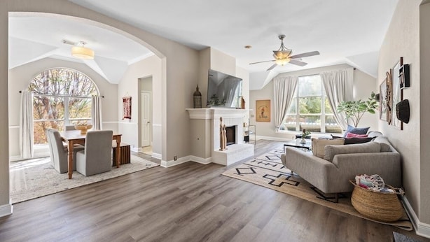 A spacious living room with a fireplace, a dining area, and a large window. - Eclipse · Artist Retreat @ Cypress Creek | Hotub | Sleeps 9 (Cedar Park)