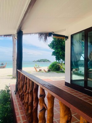 A wooden deck with a view of a beach and ocean.