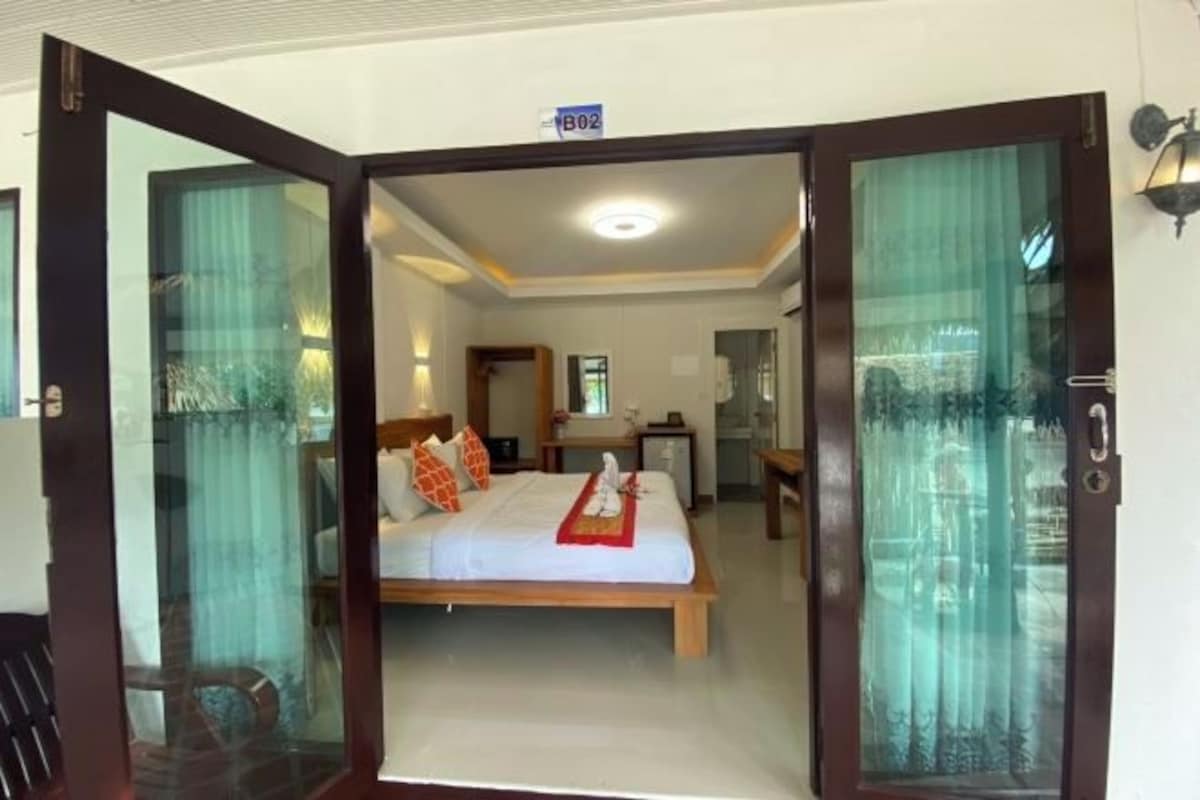 Une chambre d’hôtel avec un lit, un bureau et un miroir.