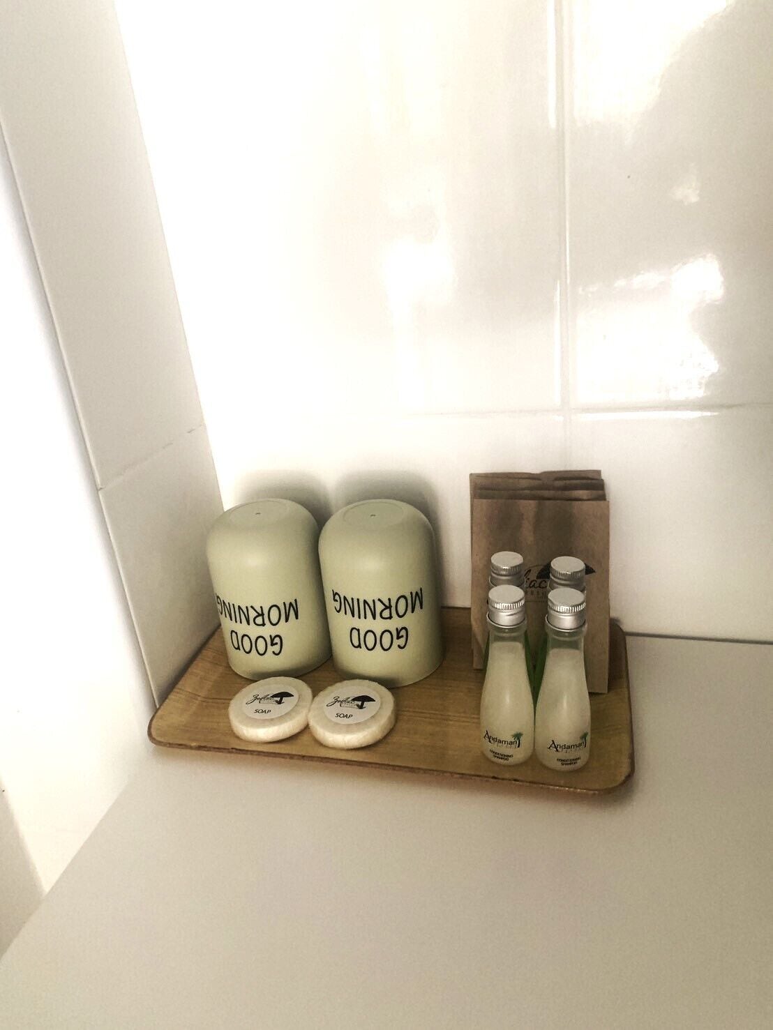 A bathroom shelf with three large jars labeled 'Good Morning' and two smaller bottles with 'Andaman' branding.