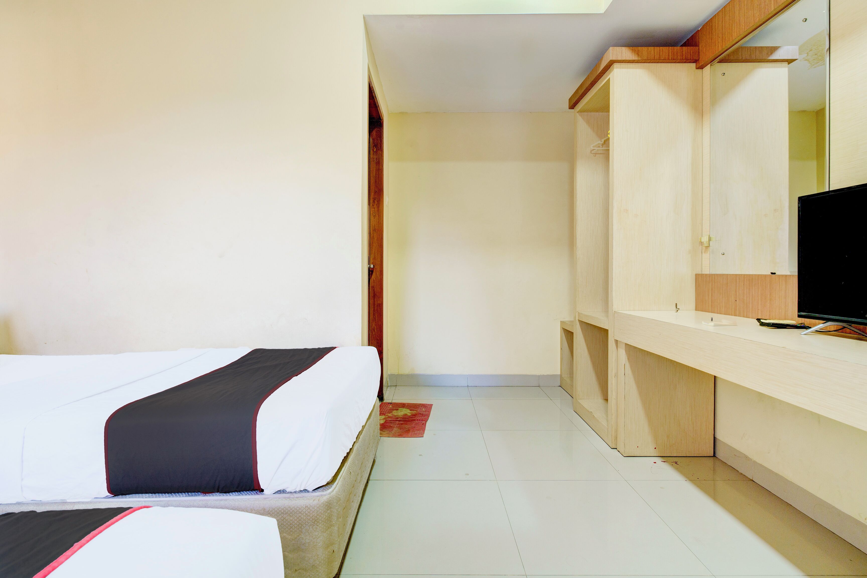 A hotel room with a bed, a desk, and a television.