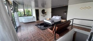 A modern bedroom with a large bed, a separate bathroom, and a view of the outdoors. - Hotel Mirador Cielo Blue-20Min Guatapé. (El Peñol)