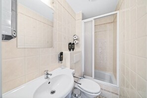 Une salle de bain avec un lavabo, des toilettes et une douche.