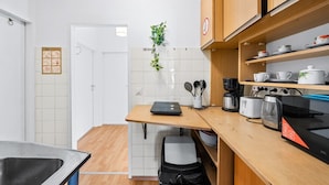 A compact kitchen with a wooden countertop, a microwave, a toaster, and a coffee maker.