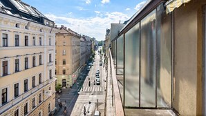 A street view with buildings on both sides, a pedestrian crossing, and a clear sky. - Flora Collections - Studio room with shared kitchen (Vienna)