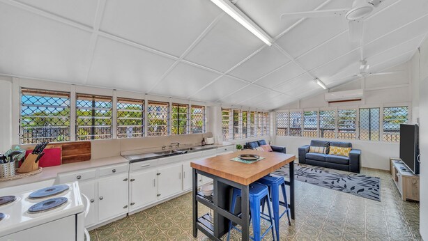 Una cocina amplia con zona de comedor, ventanas grandes y vistas al exterior.