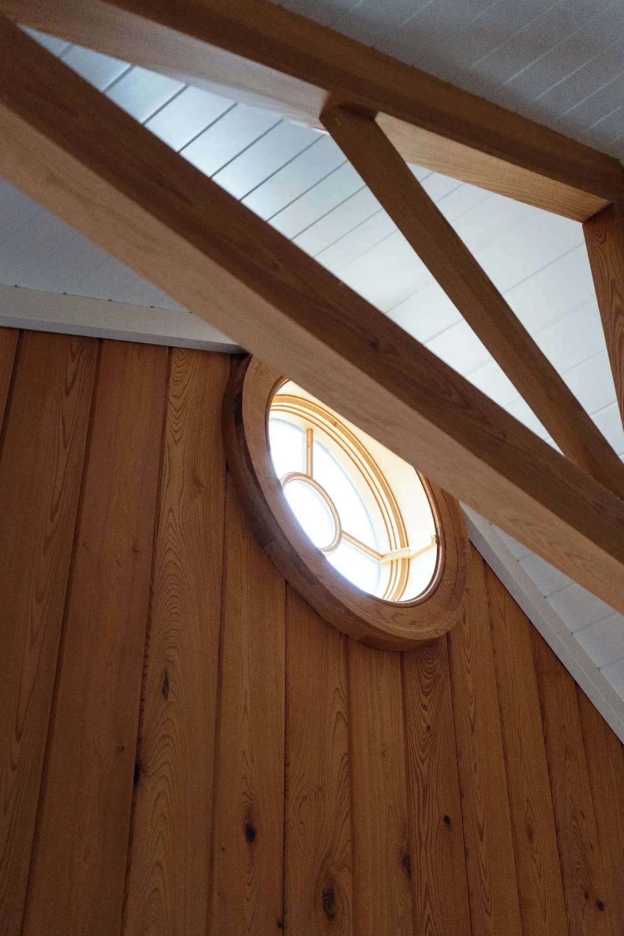 A skylight with wooden beams and a circular window.