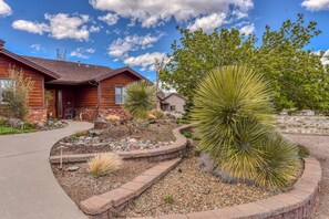 A wooden house with a stone pathway leading to the entrance. - BunnyLand Lodge | Panoramic Mt. Views | Fantastic Backyard Patio | Scenic Location in Flagstaff (Flagstaff)