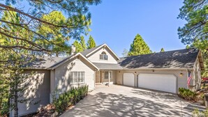 A single-story house with a garage, a front porch, and a driveway. - ACE - A Hole in One! | Right on the Golf Course | Hot Tub |  Mt Views & Pines (Flagstaff)