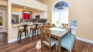 A modern kitchen with a central island, white cabinets, and a red window treatment. - Mountain Jewel | Modern Townhome in the Pines | Great Location | Near Downtown Flagstaff (Flagstaff)