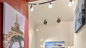 A staircase with a red wall, a painting of the Eiffel Tower, and a sunset view. - Eternal Treehouse | Hot Tub, Outdoor Paradise, Entertainment & Scenic Pine Views (Flagstaff)