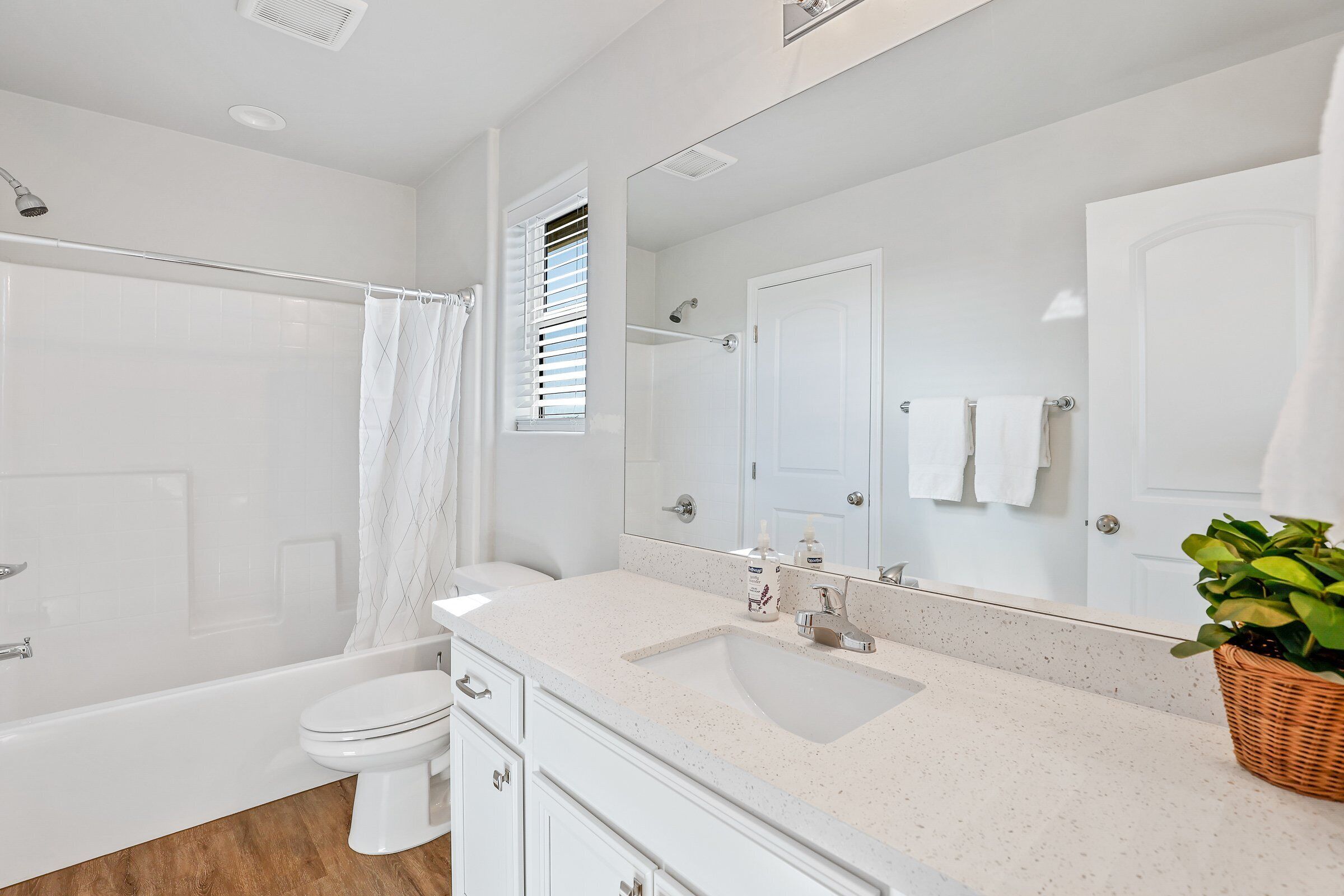 A modern bathroom with a bathtub, toilet, and sink.