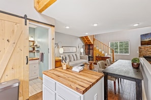 Open-plan living space with a kitchen area, dining table, and cozy seating area.