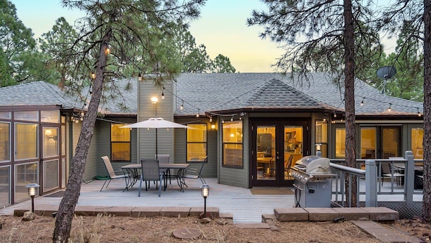 A house with a deck, outdoor seating, and a grill.