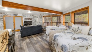 Een knus ingerichte slaapkamer met een bed, een bank, een televisie en een open haard.