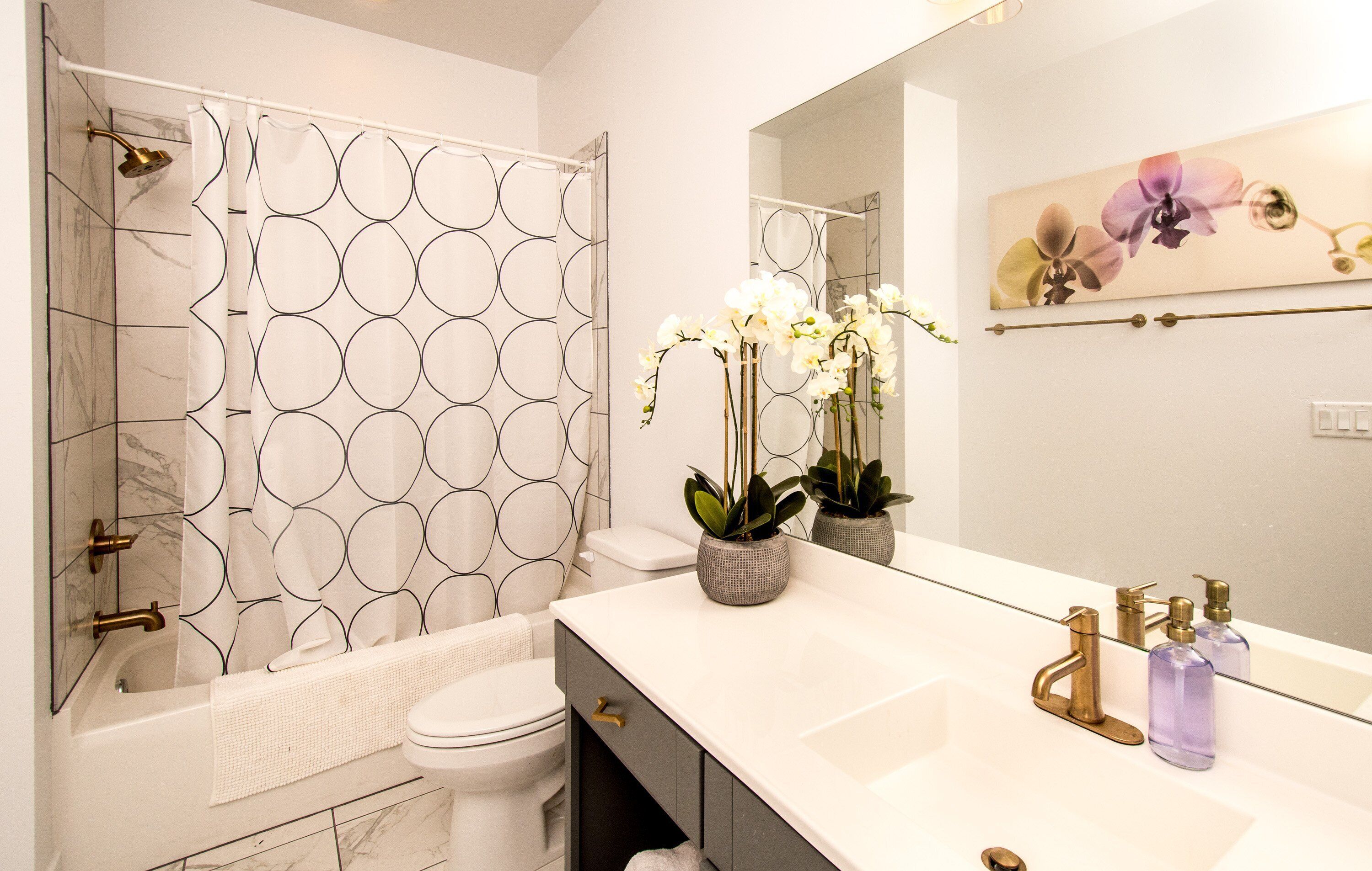 Un baño moderno con ducha, inodoro y lavamanos.
