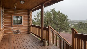 Una terraza de madera con vistas a un paisaje montañoso.
