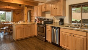 Una cocina con armarios de madera, lavavajillas de acero inoxidable y horno doble.