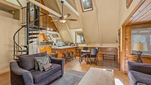 Un'ampia zona giorno in stile loft con soffitto alto, una scala a chiocciola, una sala da pranzo e una cucina.
