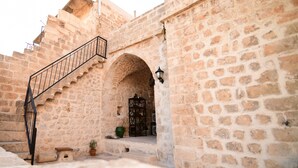 A stone building with a staircase leading to an upper level. - Sultan Konagi Hotel (Mardin)