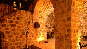 An interior courtyard with stone walls, a staircase, and potted plants. - Sultan Konagi Hotel (Mardin)