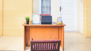 A wooden desk with a laptop, a small potted plant, and a calendar. - Hotel O Tanjung Karang Near Central Plaza Formerly Wisma Bambu (Bandar Lampung)