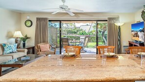 Un amplio salón con una isla grande, asientos cómodos y un televisor.